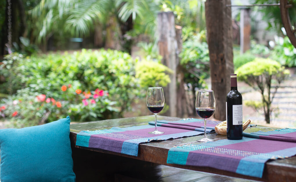 Outdoor patio with wine glasses and green garden